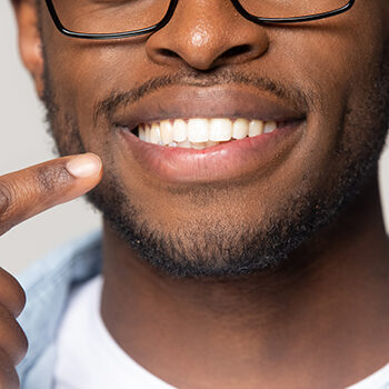 Closeup View African Guy Pointing Finger To White Toothy Smile